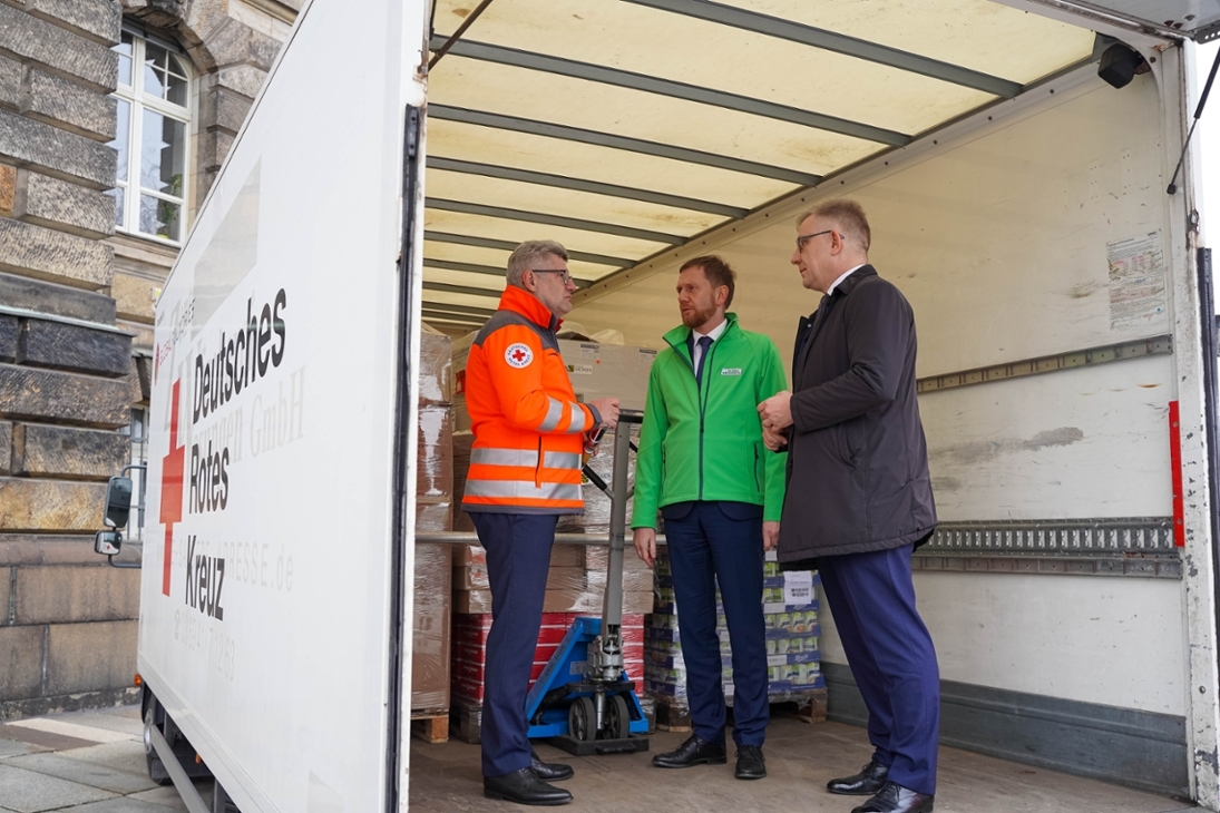 Ministerpräsident Michael Kretschmer bringt gemeinsam mit Rüdiger Unger, dem Vorsitzenden des Vorstandes des DRK Landesverbandes Sachsen e. V. (links) und Krzysztof Bramorski, dem Bevollmächtigten für Internationale Beziehungen des Marschalls von Niederschlesien (rechts), eine Hilfslieferung für die Region Dnipropetrowsk auf den Weg.