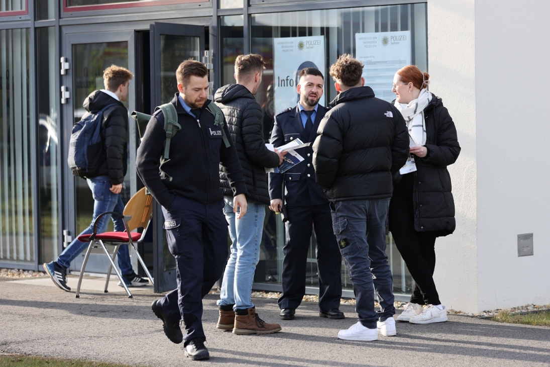 Besucher des Hochschulinformationstages an der Hochschule der Sächsischen Polizei (FH) im Gespräch mit einem Studierenden