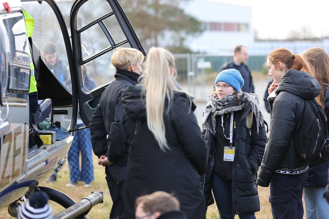 Besucher des Hochschulinformationstages an der Hochschule der Sächsischen Polizei (FH) im Gespräch mit der Pilotin eines Polizeihubschraubers