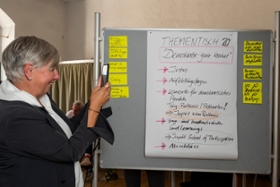 Foto: Eine Teilnehmerin vom Thementisch Nr. 20 fotografiert den Diskussionsleitfaden.
