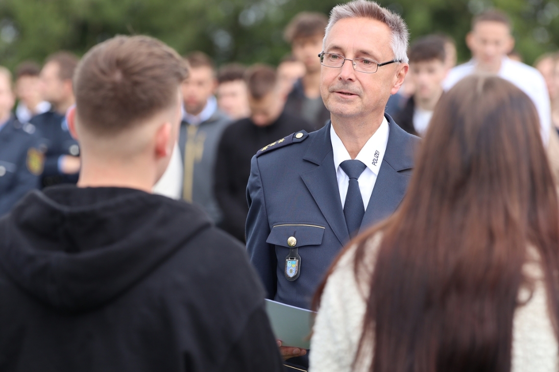 Prorektor Hanjo Protze überreicht an der Polizeifachschule Schneeberg in Vertretung des Rektors die Urkunden zur Ernennung in das Beamtenverhältnis auf Widerruf an die neu eingestellten Polizeimeisteranwärterinnen und -anwärter am ersten Tag der Ausbildung.