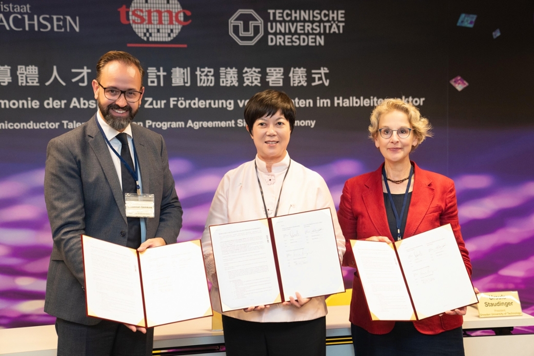 Wissenschaftsminister Sebastian Gemkow, TSMC Senior-Vice-President Lora Ho  und die Rektorin der TU Dresden, Prof. Dr. Ursula Staudinger, stehen lächelnd auf einer Pressekonferenz-Bühne und zeigen eine zuvor unterzeichnete Vereinbarung zum Semiconductor Talent Incubation Program bei TSMC in Taichung.