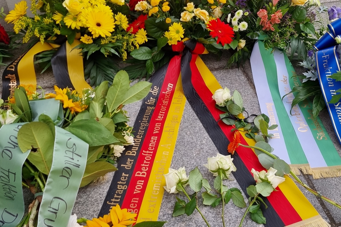 Gebinde am Tatort in der Rosmaringasse zu Ehren des Opfers, seiner Hinterbliebenen und aller Tatzeugen vom Bundesopferbeauftragten, Pascal Kober, der Sächsischen Opferbeauftragten, Iris Kloppich, der Stadtverwaltung Dresden, von Parteien und Initiativen