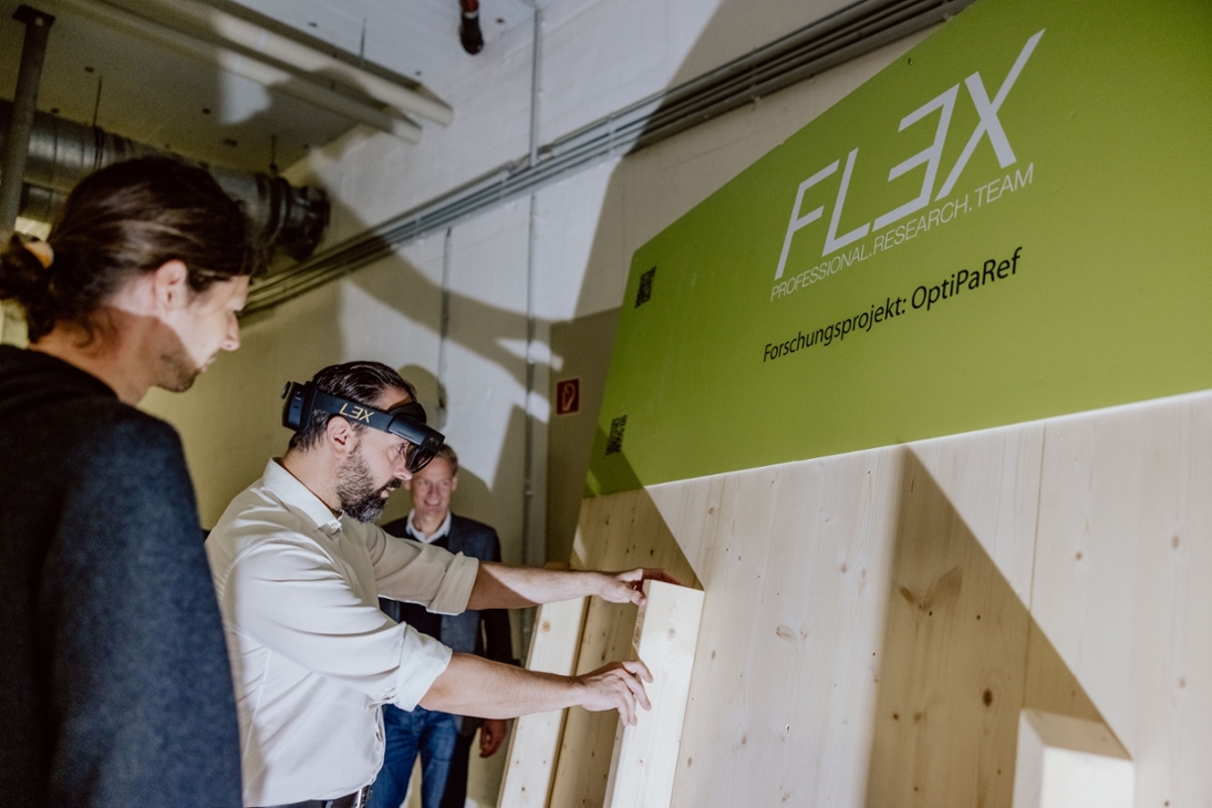 Wissenschaftsminister Sebastian Gemkow bei seiner heutigen Pressetour zum Thema Nachhaltigkeit in der HTW Leipzig. Hier wird u. a. zu Augmented Reality (AR) und Robotik im Bauhandwerk geforscht. Im neuen Smart Manufacturing Lab an der HTWK Leipzig erprobt die Forschungsgruppe „FLEX“ digital basierte Vorfertigungskonzepte und verfolgt den Ansatz zu mehr Nachhaltigkeit zum Einsatz von Holz als Baustoff.