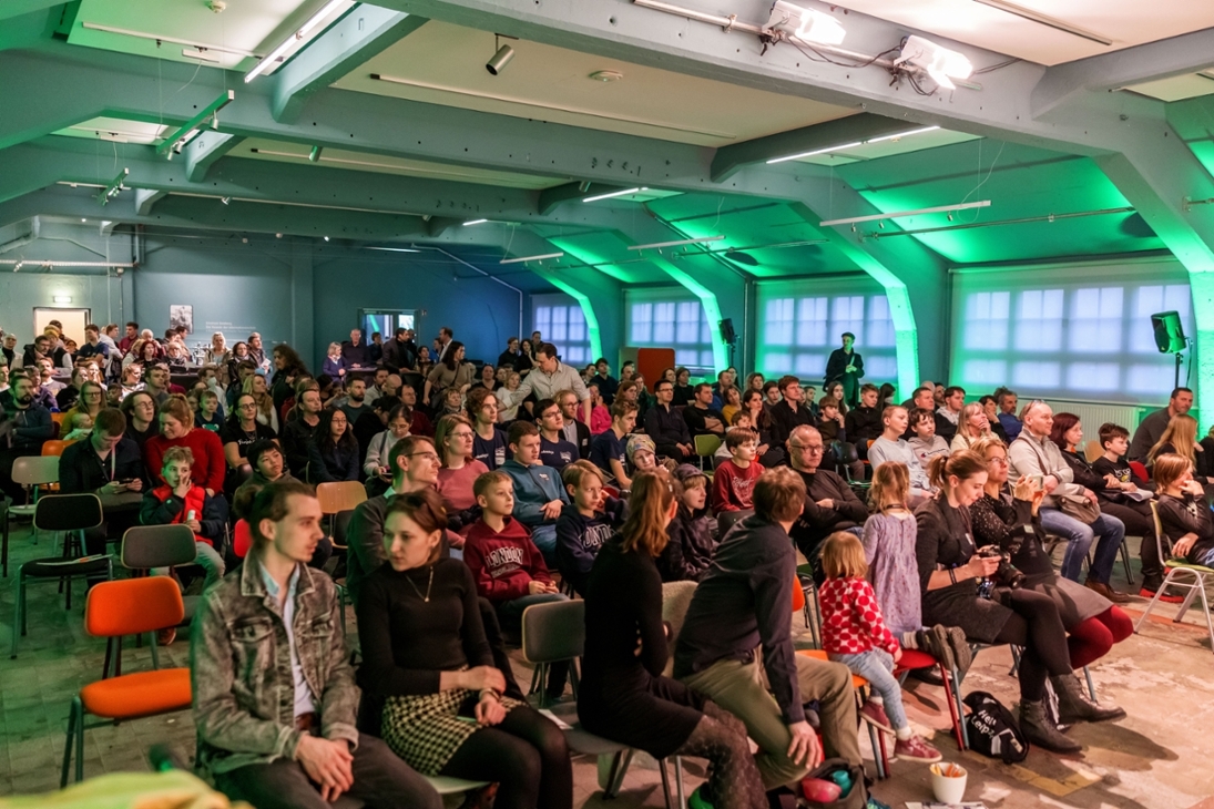 Besucherinnen und Besucher verfolgen die unterhaltsamen und spannenden Vorträge von Wissenschaftlerinnen und Wissenschaftlern.