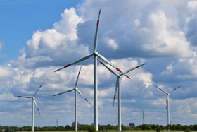 Foto: Windparkanlage mit fünf Windkraftanlagen vor bewölktem Himmel
