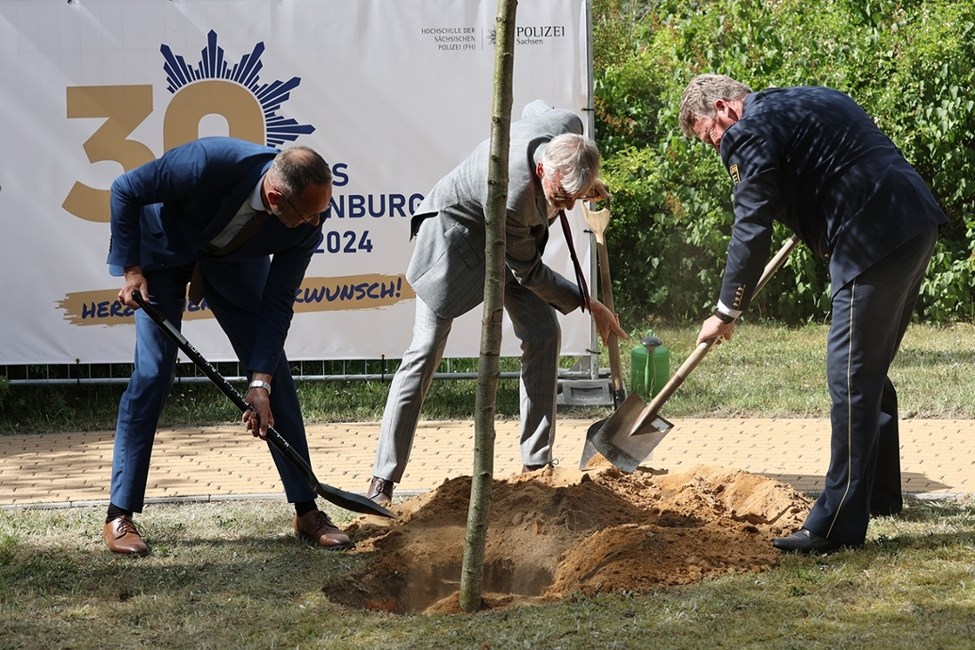Staatsminister Armin Schuster, Landespolizeipräsident Jörg Kubiessa und Rektor Dirk Benkendorff pflanzen im Garten der Hochschule der Sächsischen Polizei (FH) am Campus Rothenburg einen Kirschbaum.