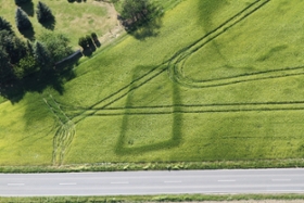 Foto: Aus der Luft betrachtet, zeichnet sich im grünen Getreide deutlich ein großes trapezförmiges Grabenwerk aus dem mittleren Neolithikum (um 3500 v.Chr.) ab