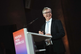 Foto: Prof. Gerhard Fettweis steht nach seiner Auszeichnung freudig am Rednerpult der Gala zur Verleihung der HighTech-Preise Bayern 2025