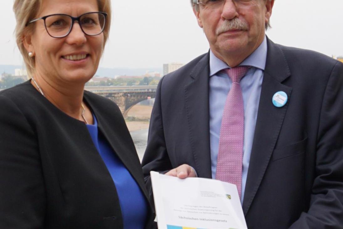 Sozialministerin Barbara Klepsch hält zusammen mit dem Behindertenbeauftragten Stephan Pöhler das Eckpunktepapier für ein Sächsisches Inklusionsgesetz in den Händen