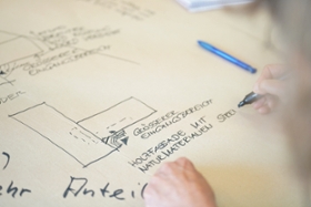 Foto: Nahaufnahme von Notizen einer Workshop-Teilnehmerin zum Architekten-Entwurf für den geplanten Neubau.