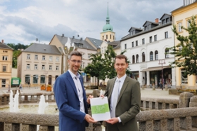 Foto: Der Präsident der Landesdirektion Sachsen, Béla Bélafi (rechts im Bild), übergibt dem Oberbürgermeister der Großen Kreisstadt Sebnitz, Ronald Kretzschmar, eine Bedarfszuweisung in Höhe von 1,4 Millionen Euro für die Ausrichtung des Tag der Sachsen 2025.