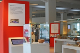 Foto: Die Foyerausstellung kombiniert archäologische Objekte mit Medienstationen und Hintergrundinformationen zur Arbeit der Restauratorinnen und Restauratoren.