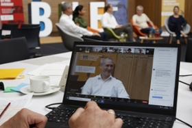 Foto: Bildschirm eines Laptops, der das hybride Veranstaltungsformat verdeutlicht