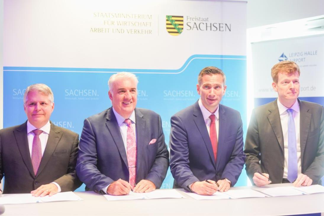 Jon Burgoyne, Executive Vice President Sierra Nevada Corporation Inc., Dave Jackson, Geschäftsführer der DRA GmbH, Martin Dulig, Sächsischer Staatsminister für Wirtschaft, Arbeit und Verkehr und Vize-Ministerpräsident des Freistaates Sachsen und Götz Ahmelmann, Vorstandsvorsitzender der Mitteldeutschen Flughafen AG, unterzeichnen eine Absichtserklärung, um die Endmontagelinie der weiterentwickelten Dornier 328 am Flughafen Leipzig/Halle zu errichten.