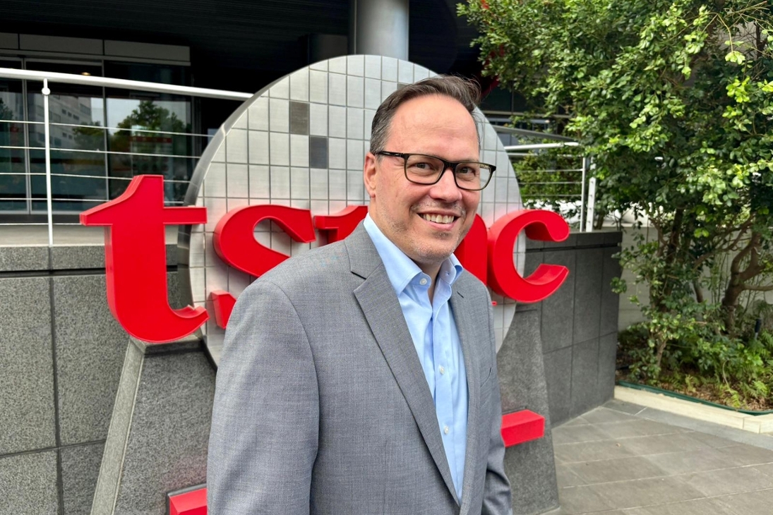 Wirtschaftsminister Dirk Panter steht vorm einem TSMC-Schriftzug vorm TSMC-Headquarter in Hsinchu