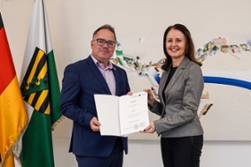 Foto: Wissenschaftsstaatssekretärin Prof. Heike Graßmann überreicht Kanzler Daniel Andrae die Ernnnungsurkunde.
