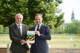 Foto: Landtagspräsident Alexander Dierks und Landesbeauftragter Michael Welsch auf der Freitreppe vor dem Plenarsaal des Sächsischen Landtags mit einem Exemplar der sächsischen Verfassung in Leichter Sprache