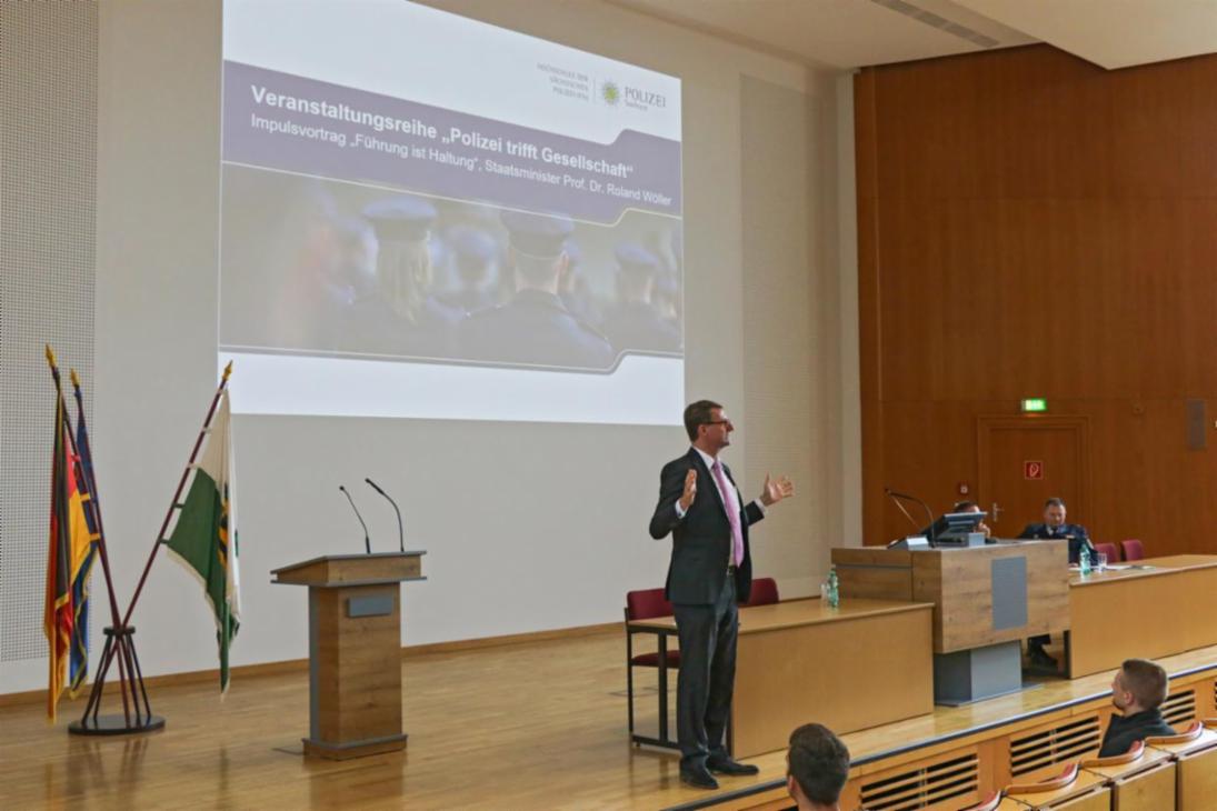 Staatsminister des Innern Prof. Dr. Roland Wöller während eines Vortrages auf dem Podium der Aula am Campus Bautzen der Hochschule der Sächsischen Polizei (FH)