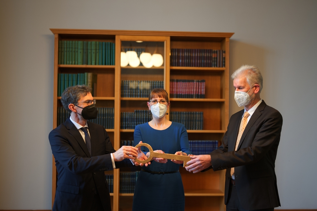 Der scheidende Präsident des Oberlandesgerichtes Dresden Gilbert Häfner (rechts im Bild) überreicht seinem Nachfolger Dr. Leon Ross (links im Bild) im Beisein von Justizministerin Katja Meier einen symbolischen Schlüssel für das Oberlandesgericht.