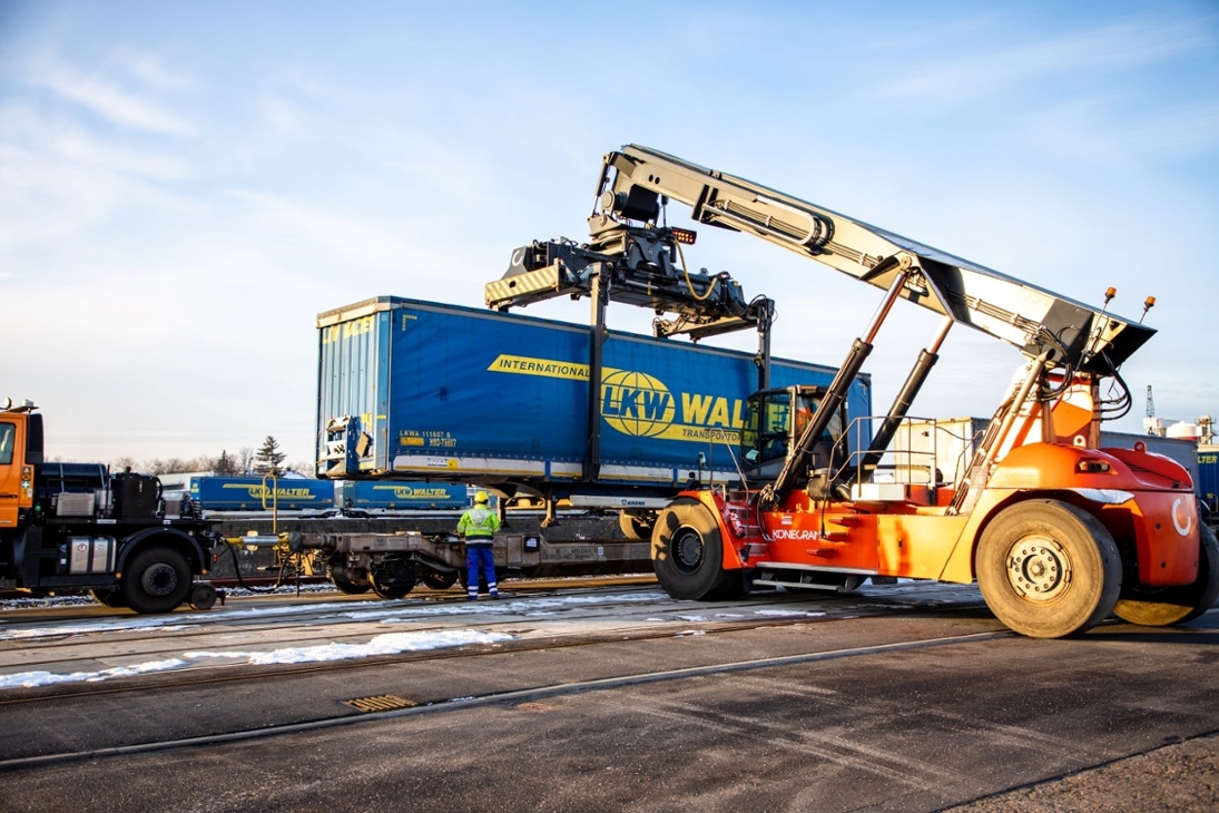 Sattelauflieger wird mit Kran direkt auf Güterzug verladen