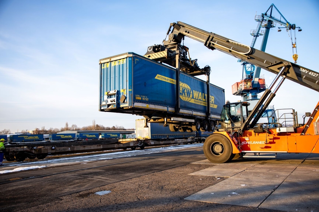 Sattelauflieger wird mit Kran direkt auf Güterzug verladen